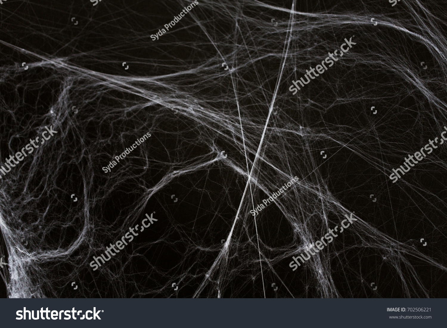 halloween, decoration and horror concept - ecoration of artificial spider web over black background #702506221