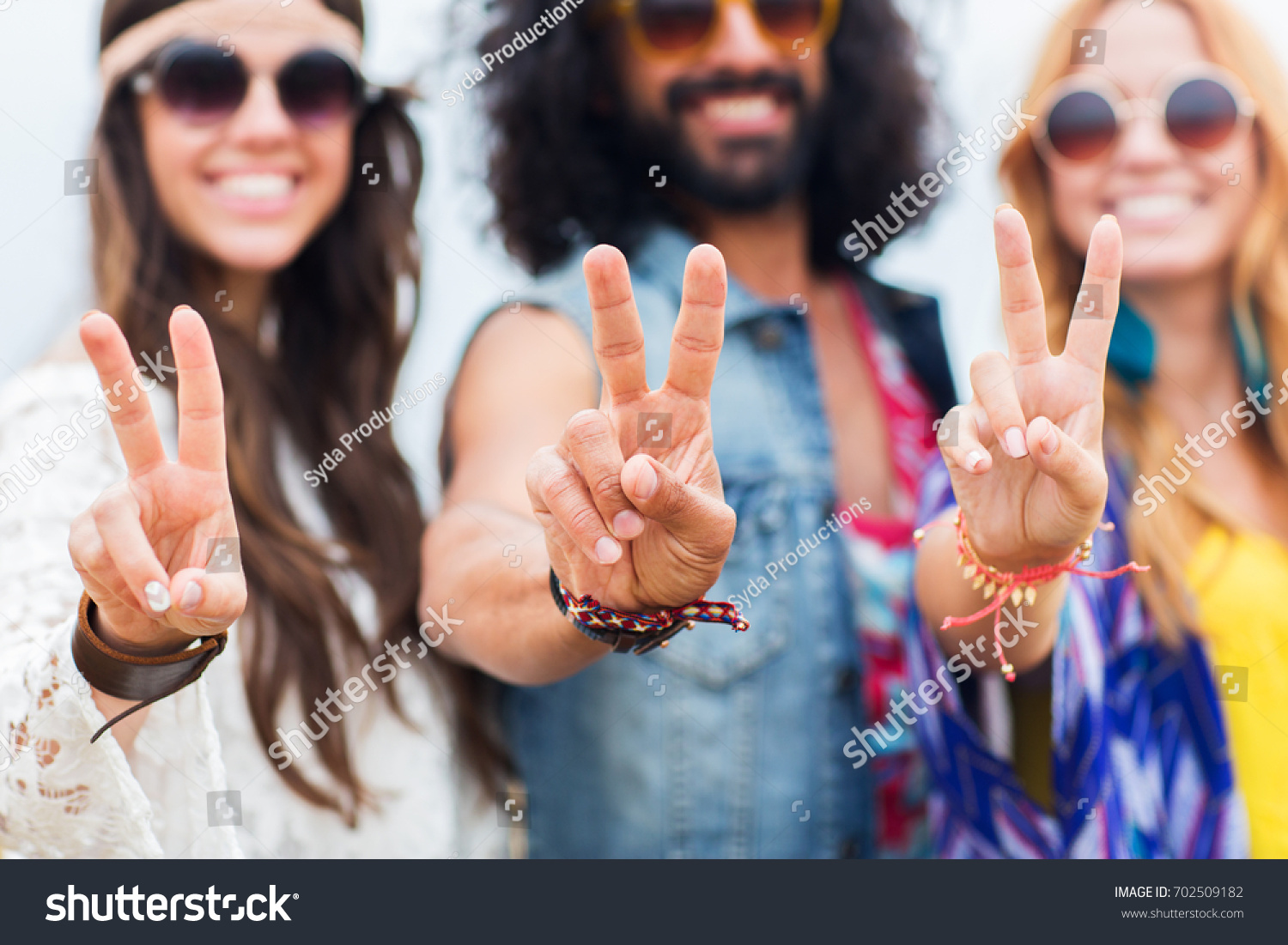 youth culture, gesture and people concept - smiling young hippie friends in sunglasses showing peace hand sign outdoors #702509182