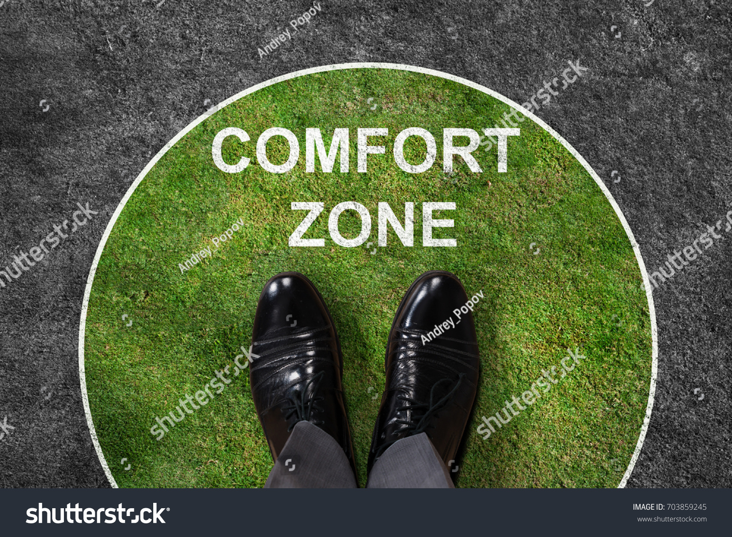 Businessman standing on green and gray carpet with comfort zone text on it #703859245