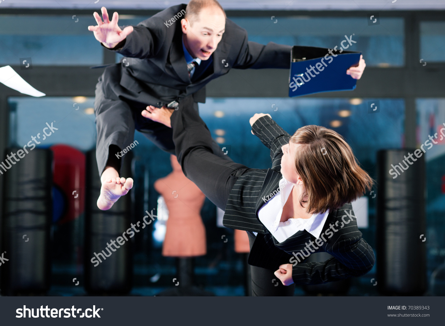 Business concept - People in a gym in martial arts training exercising Taekwondo, both wearing suits #70389343