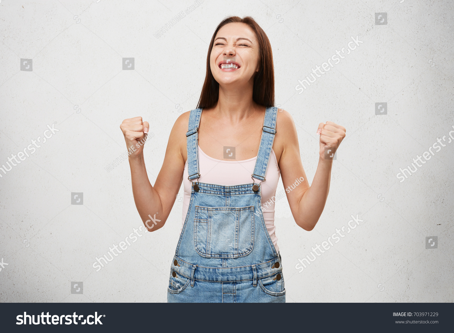 People, success, winning, victory, excitement, goals, determination and achievement concept. Joyful excited lucky student woman cheering, celebrating success, screaming yes with clenched fists #703971229