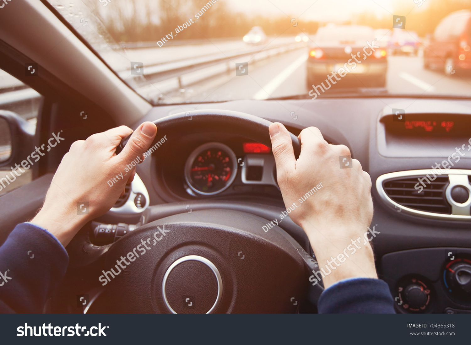 traffic jam, driving car on highway, close up of hands on steering wheel in sunny day #704365318