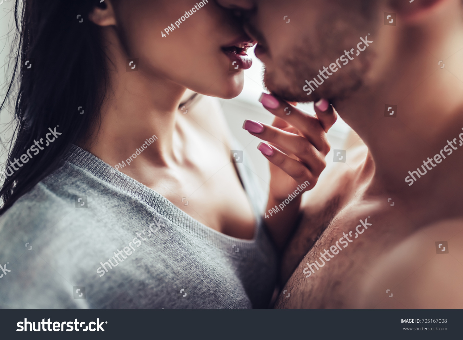 Close-up of young romantic couple is kissing and enjoying the company of each other at home. #705167008