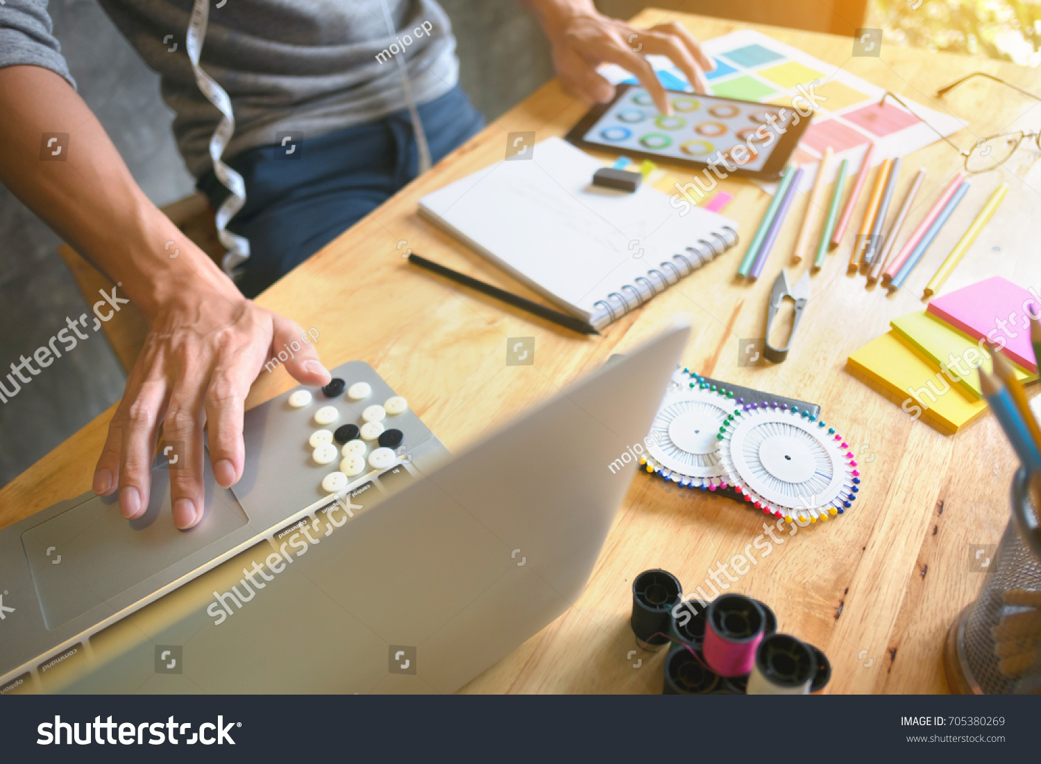 creative / fashion designer working on laptop and digital tablet at modern home studio #705380269
