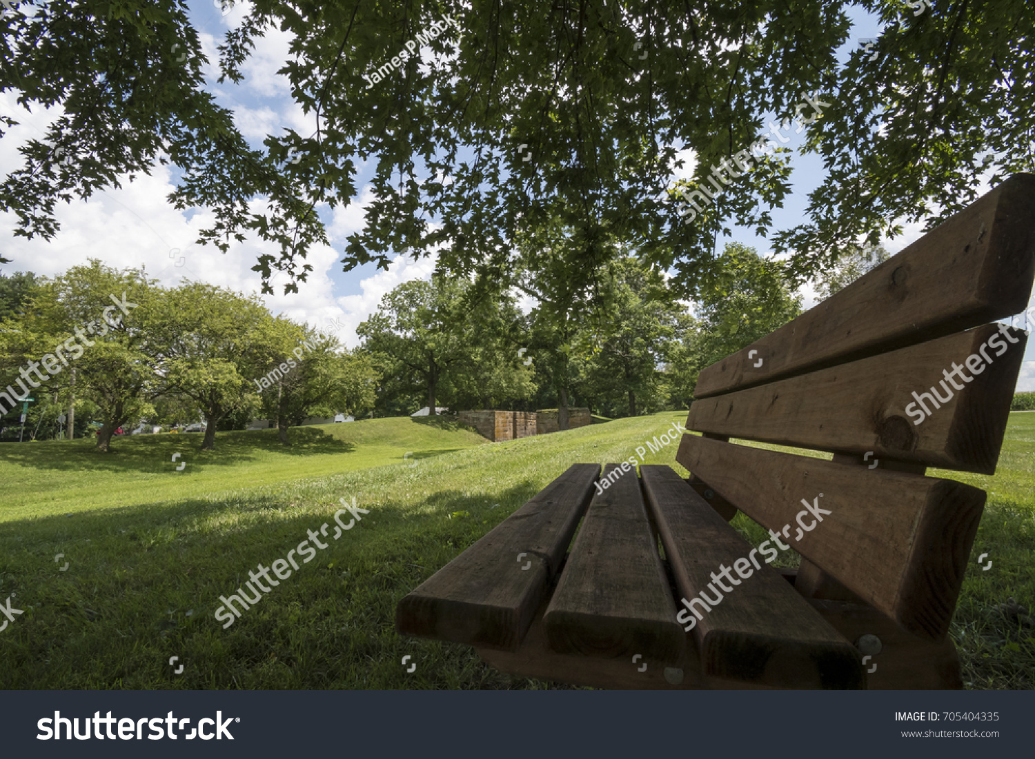 Shaded Park Bench #705404335