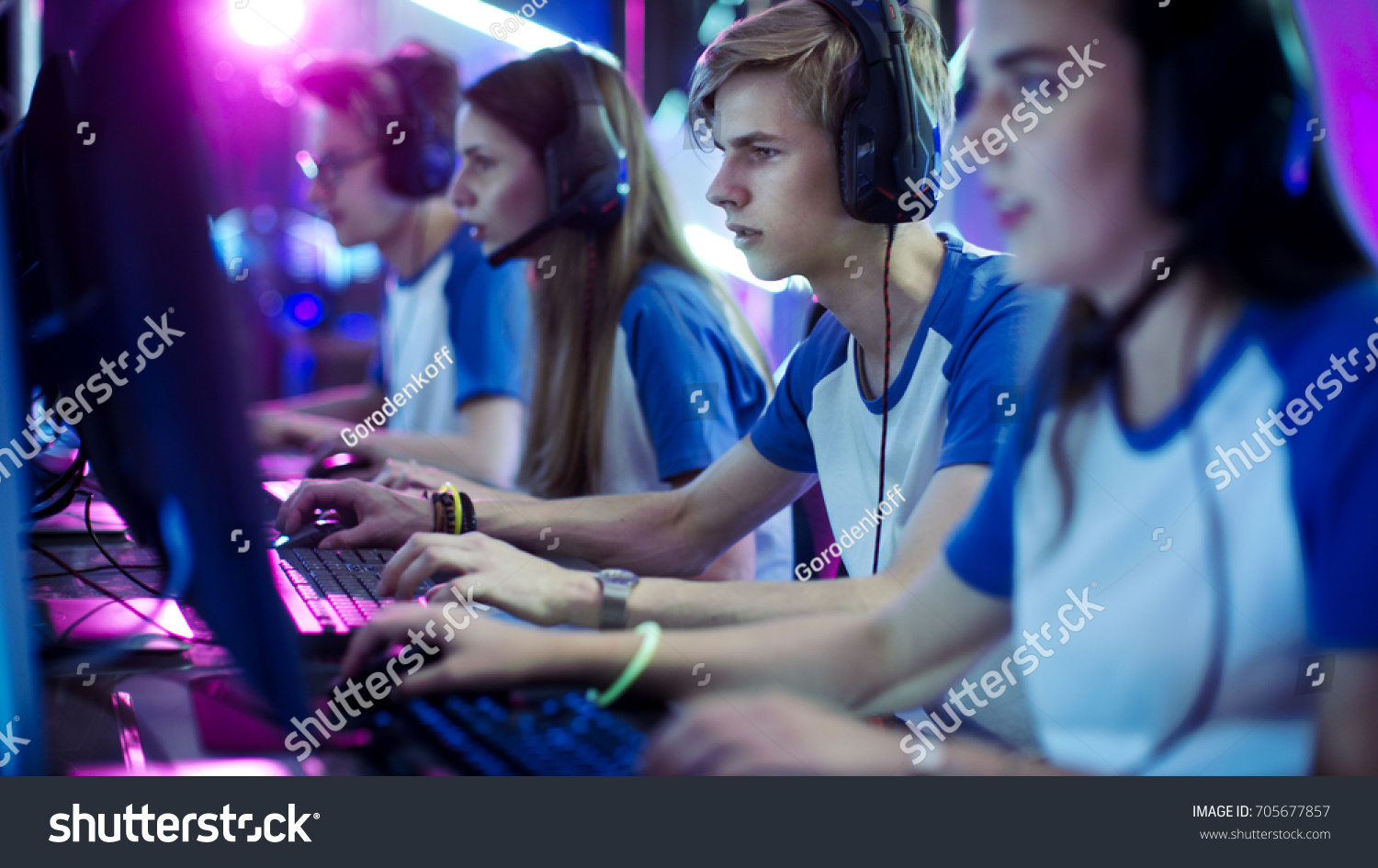 Team of Professional eSport Gamers Playing in Competitive Video Games on a Cyber Games Tournament. They using Microphones. #705677857