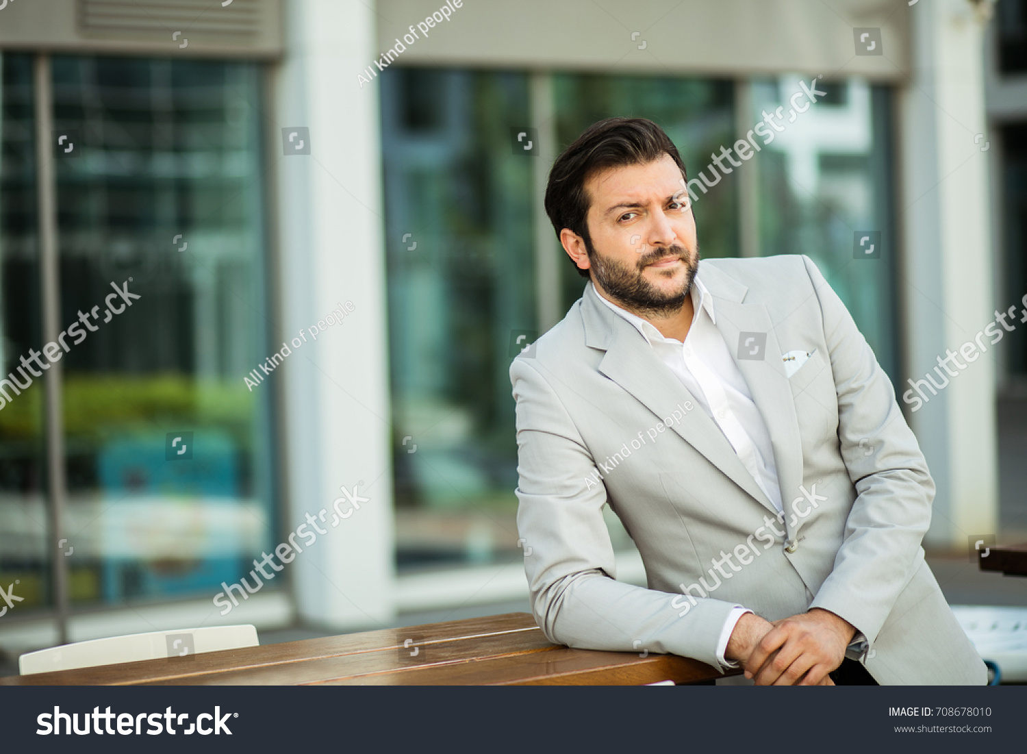 succesful man in white shirt standing next to an office building in a small break outside in a corporate area #708678010