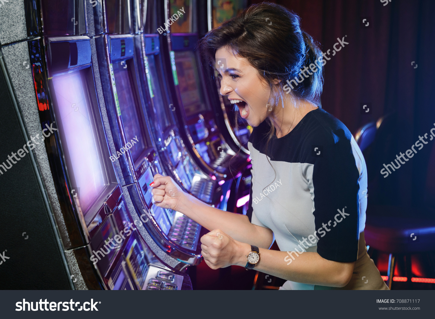 Happy woman playing slot machines in the casino #708871117