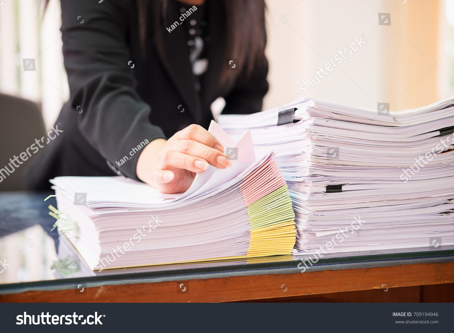 Asian business woman office workers holding are arranging documents of unfinished documents on office desk,Stack of business paper,document management,Businesswoman examining documents
 #709194946
