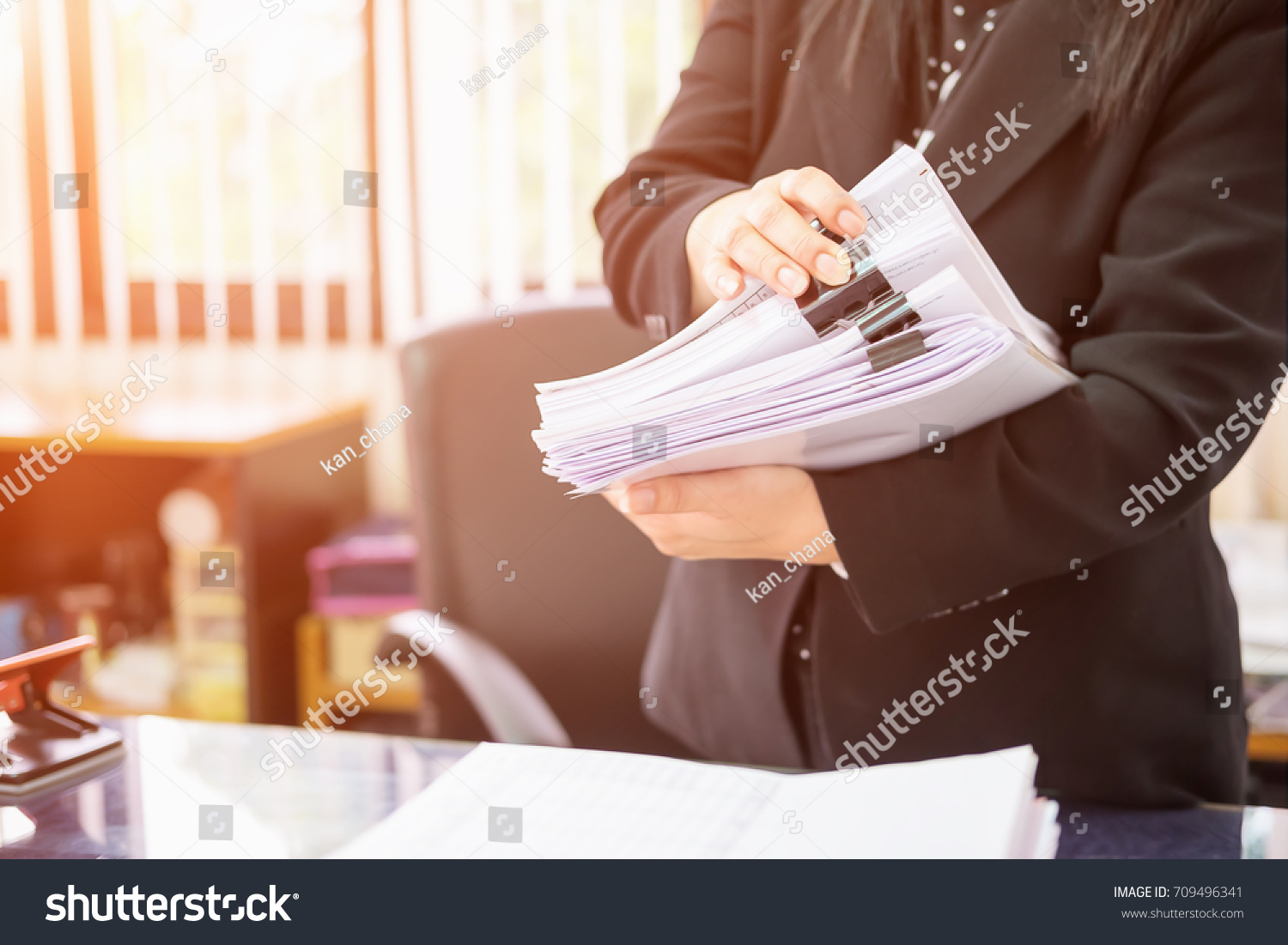 Asian business woman office workers holding are arranging documents of unfinished documents on office desk,Stack of business paper,document management,Businesswoman examining documents
 #709496341