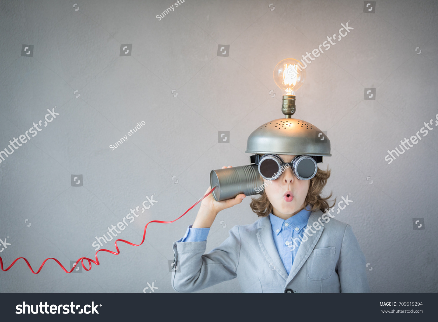 Portrait of child in classroom. Child with toy virtual reality headset in class. Funny kid with light bulb. Communication, idea and innovation technology concept. Back to school #709519294