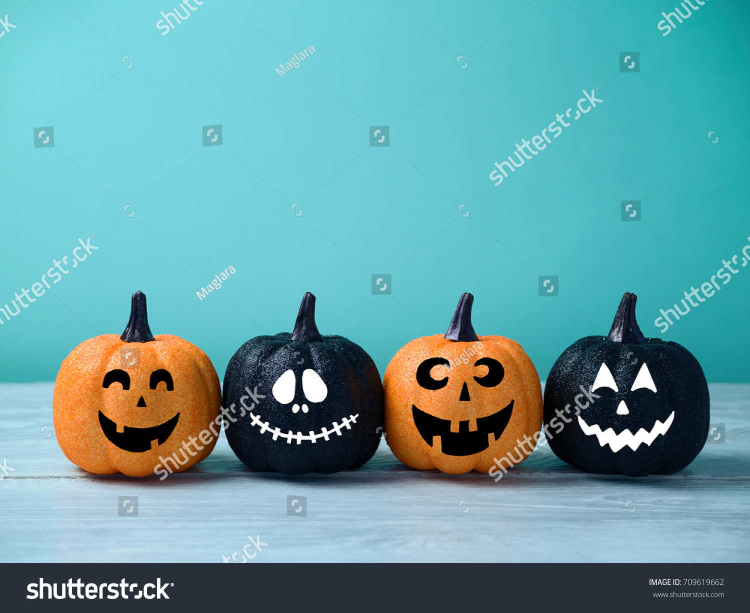 Halloween glitter pumpkin jack o lantern decor with funny faces.  #709619662