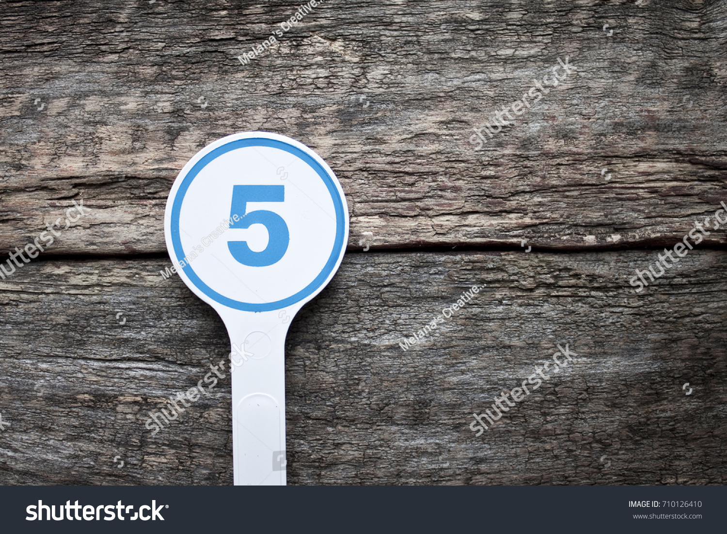 Plate number on a old wooden background. Numbers for lists or numbering concept.  #710126410