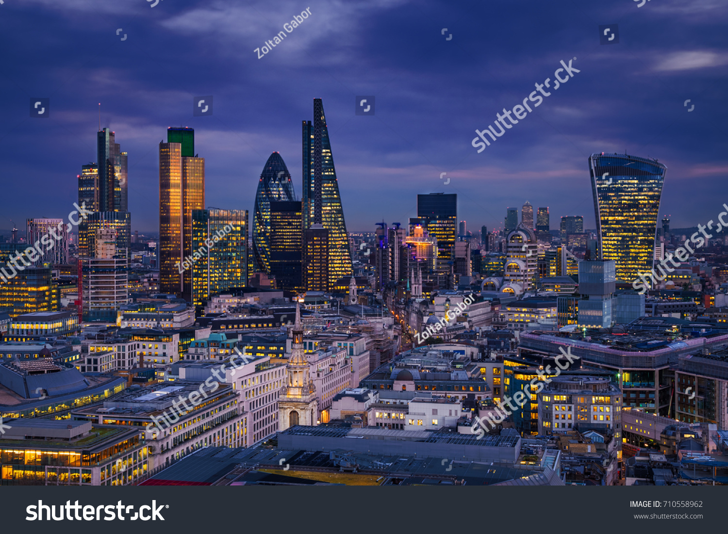 London, England - Panoramic skyline view of Bank district of London with the skyscrapers of Canary Wharf at the background at blue hour #710558962