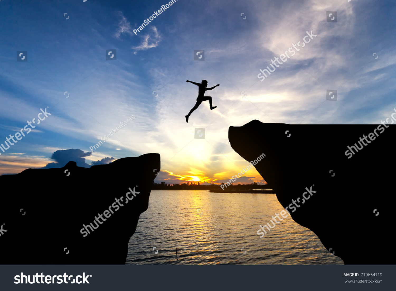 Man jump through the gap between hill.man jumping over cliff #710654119