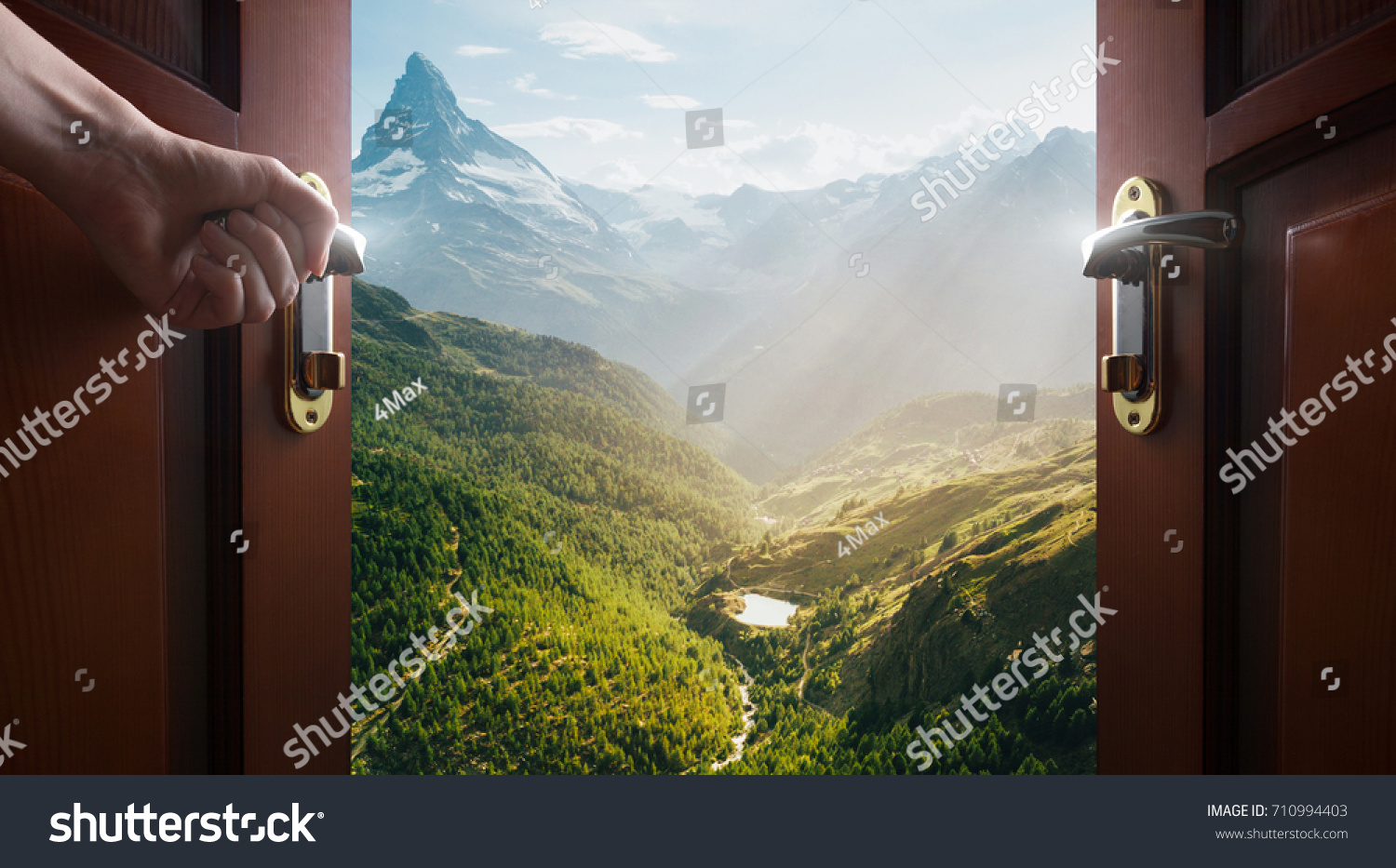 hand opens empty room door to nature and mountains #710994403
