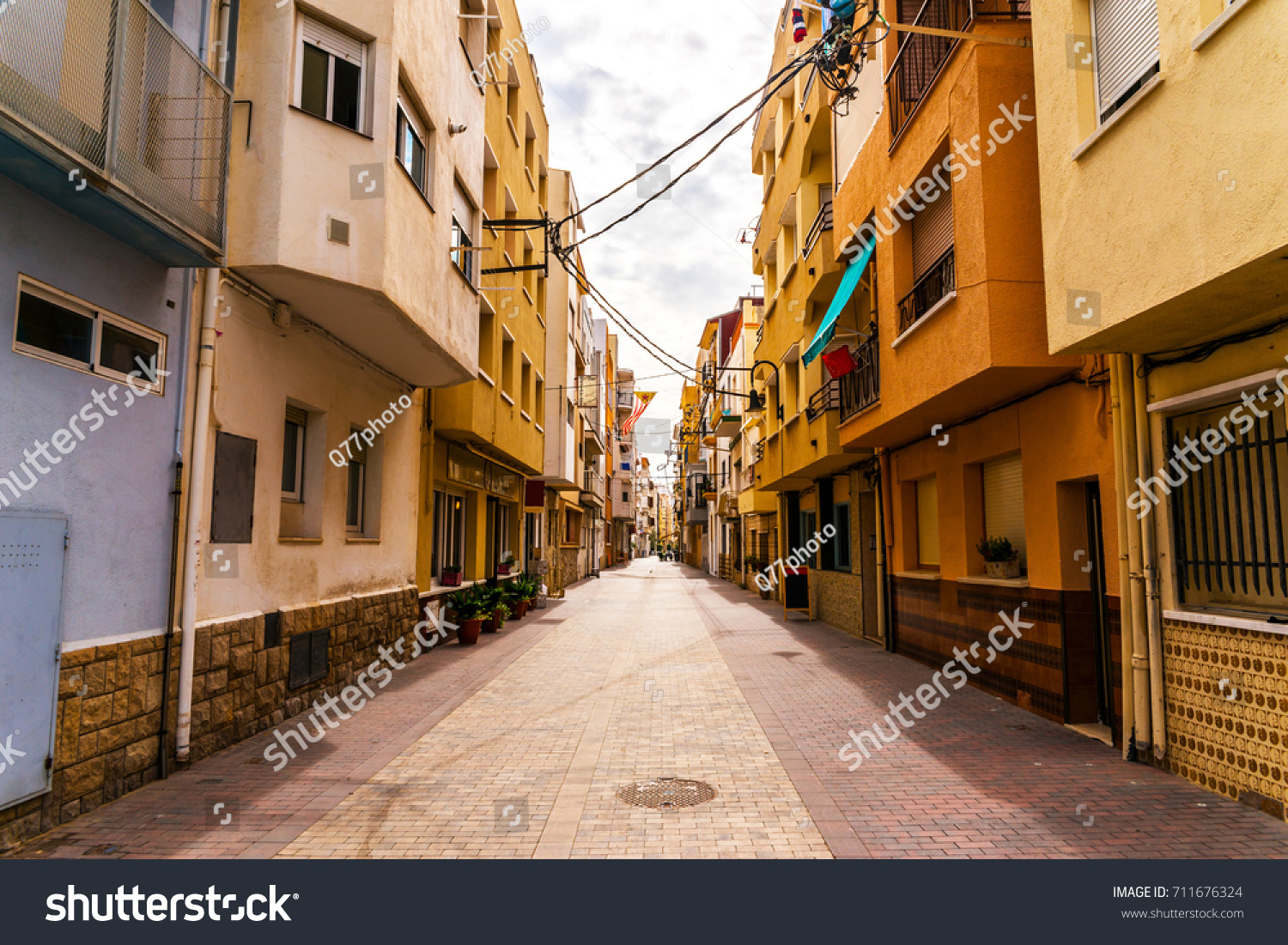 beautiful, picturesque street, narrow road, colorful facades of buildings, Spanish architecture, sunny day #711676324