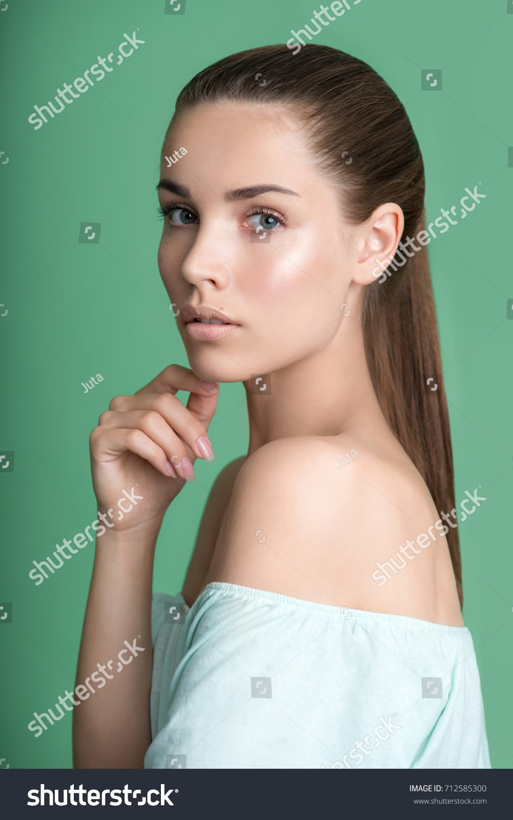 Portrait of beauty model with natural nude make up on green background. Beautiful young woman with clean perfect skin. Spa, skincare and wellness.  #712585300