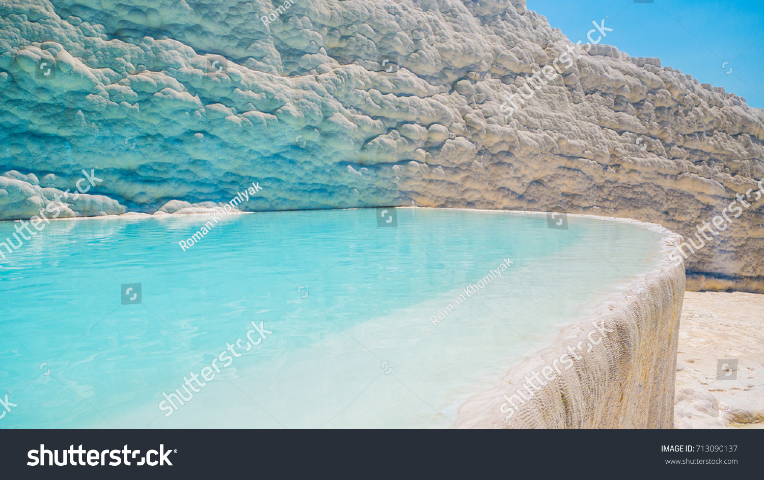 Flowing slowly down the huge mountainside, mineral water collect in terraces, dripping over balconies of stalactites into milky pools.  Pamukkale, Turkey. #713090137