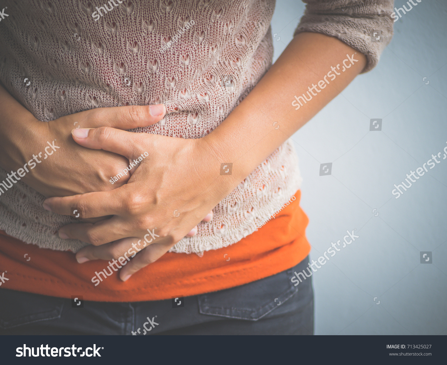 Young woman having painful  stomachache. Chronic gastritis. Abdomen bloating concept. #713425027