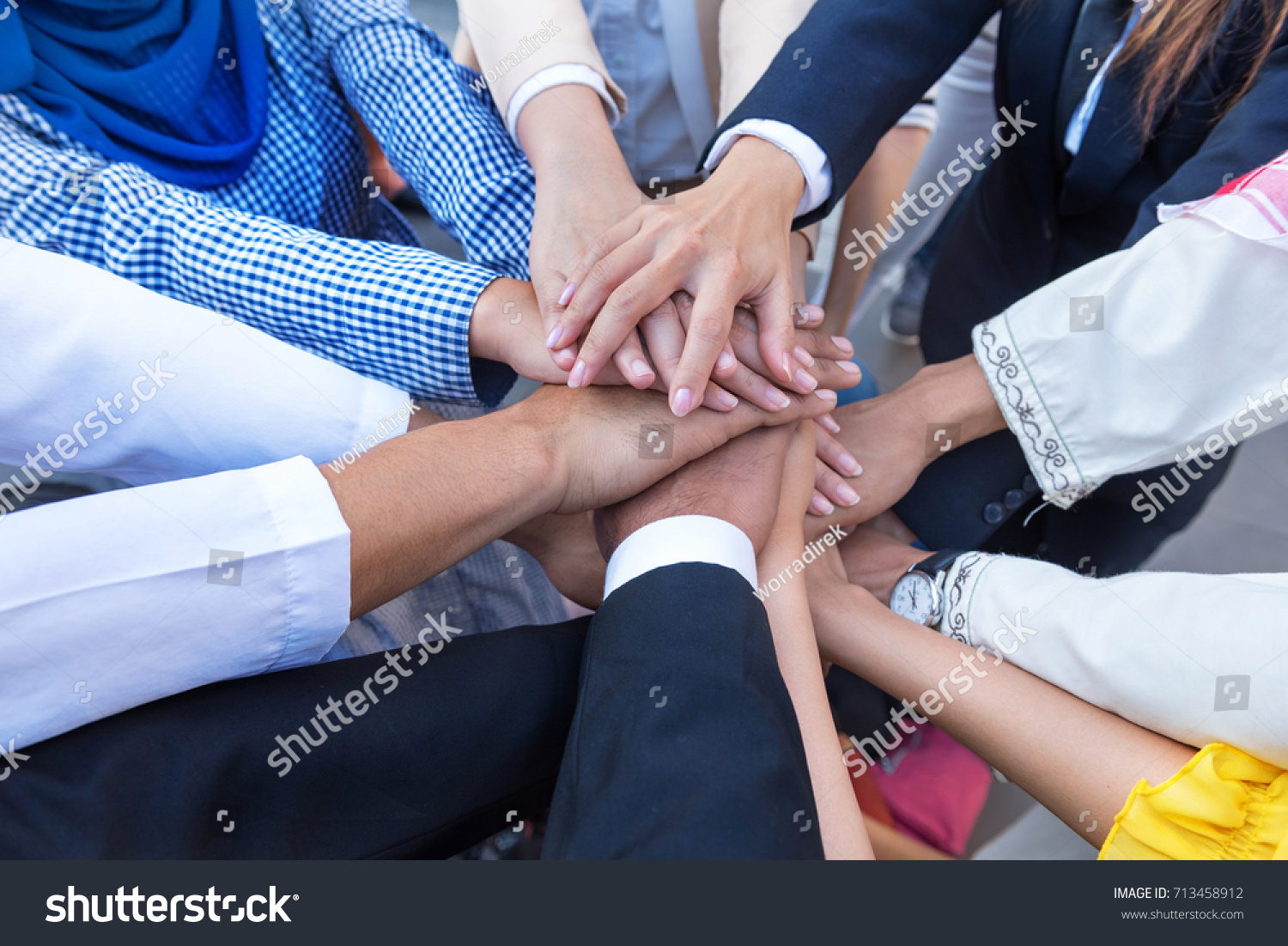 
A meeting of Arab and Asian employees to work together as a team for success. hand of the group represents teamwork. officer in company confident and work happy by agreement teamwork leader, follower #713458912
