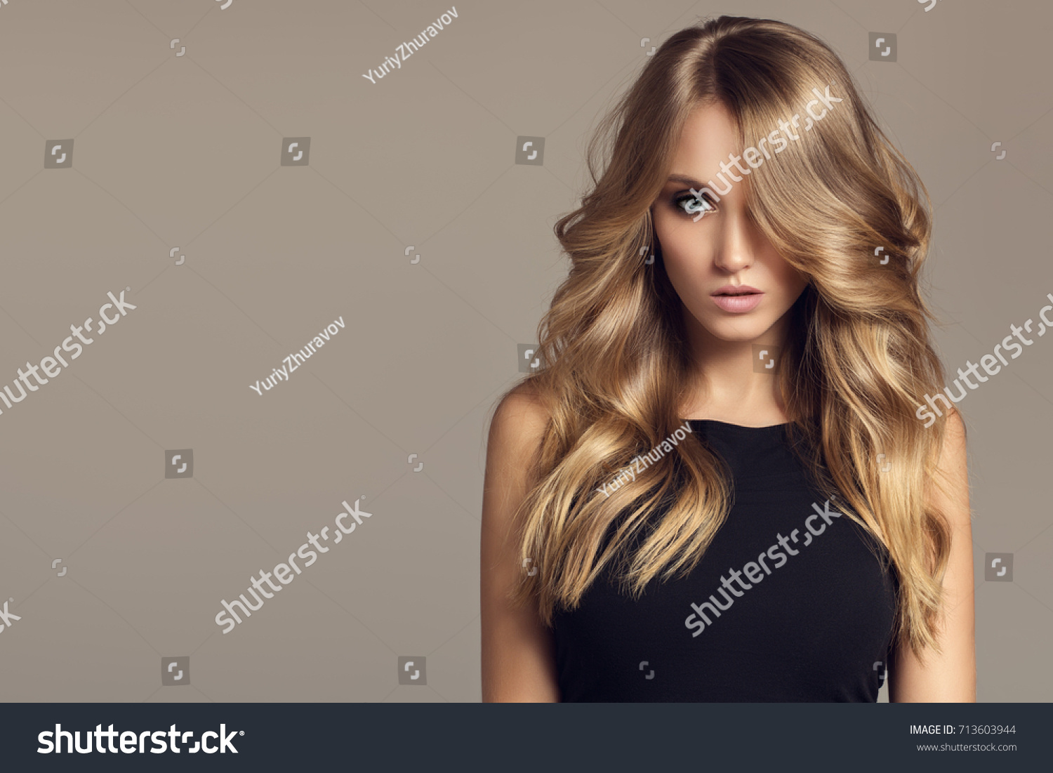 Blond woman with long curly beautiful hair.  #713603944