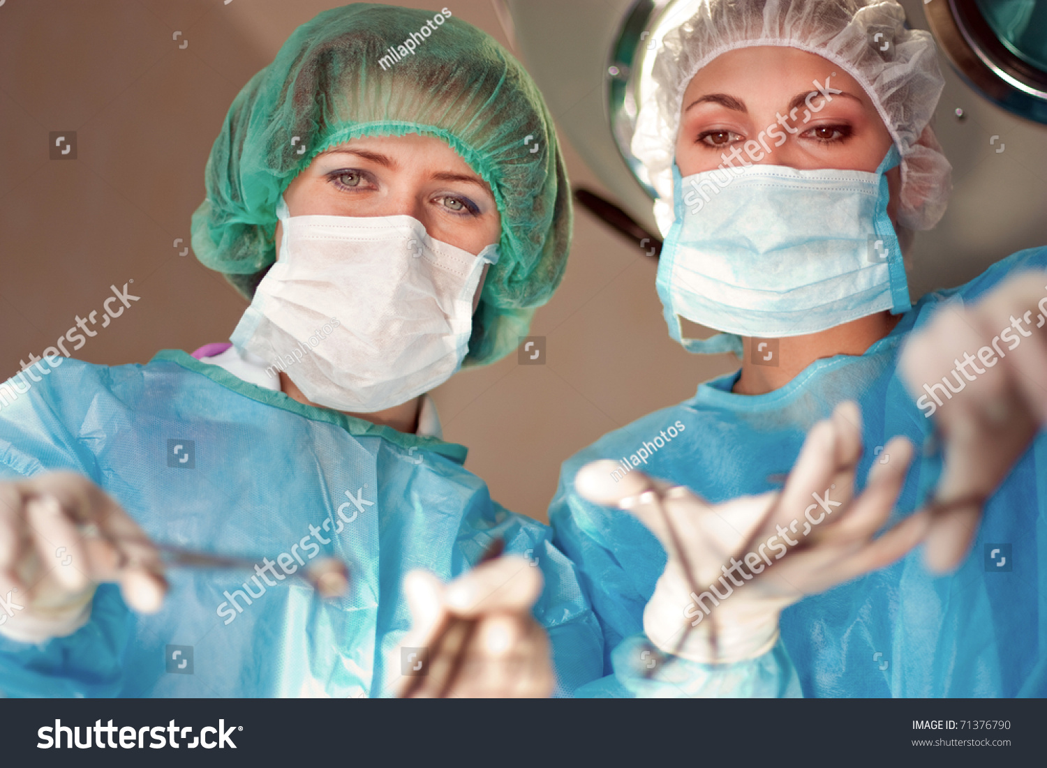 Two female surgeons operate in the hospital #71376790
