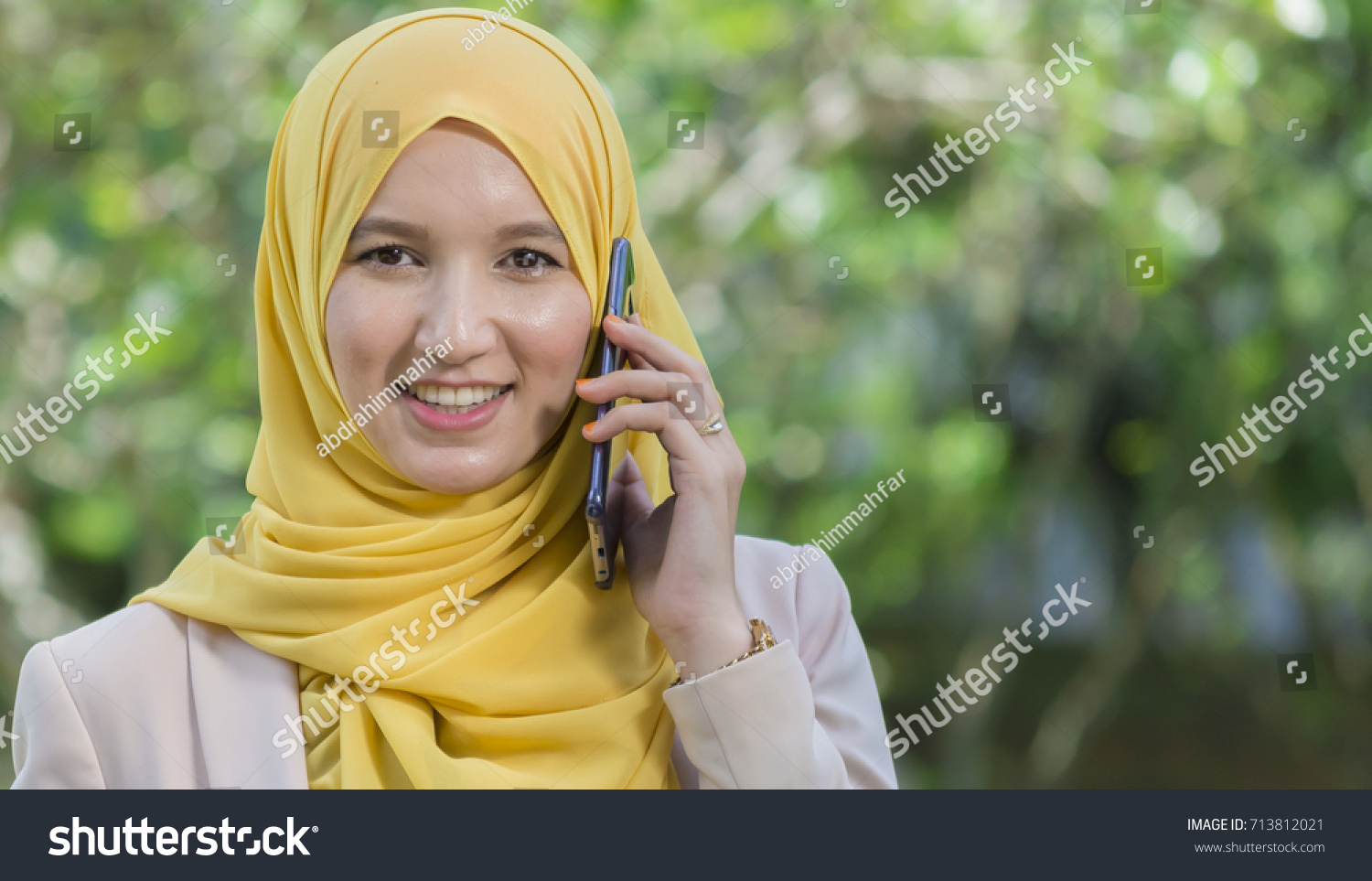 Businesswoman in hijab in the park talking on cell phone. #713812021