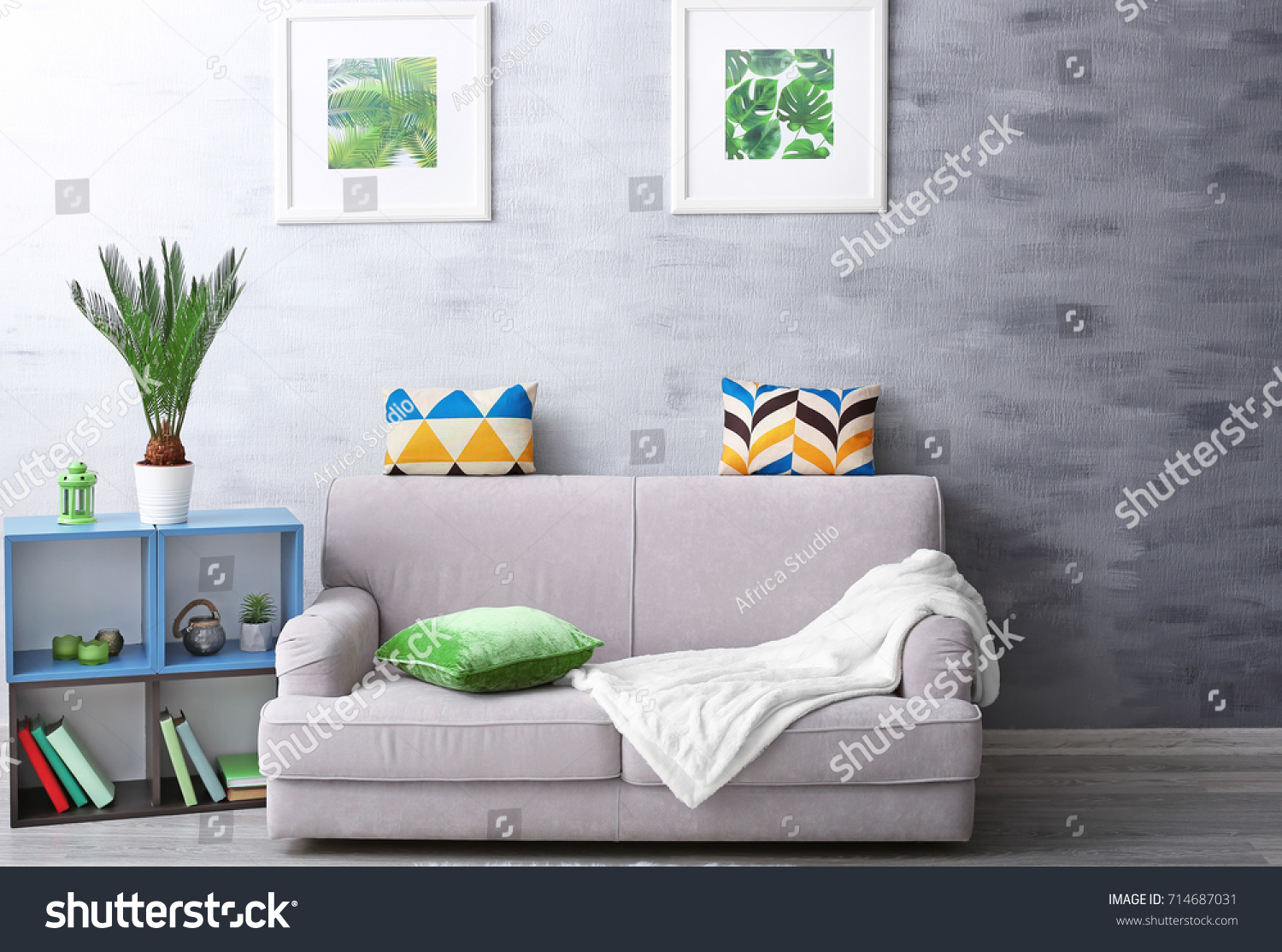 Modern living room design with framed pictures of tropical leaves and sago palm #714687031