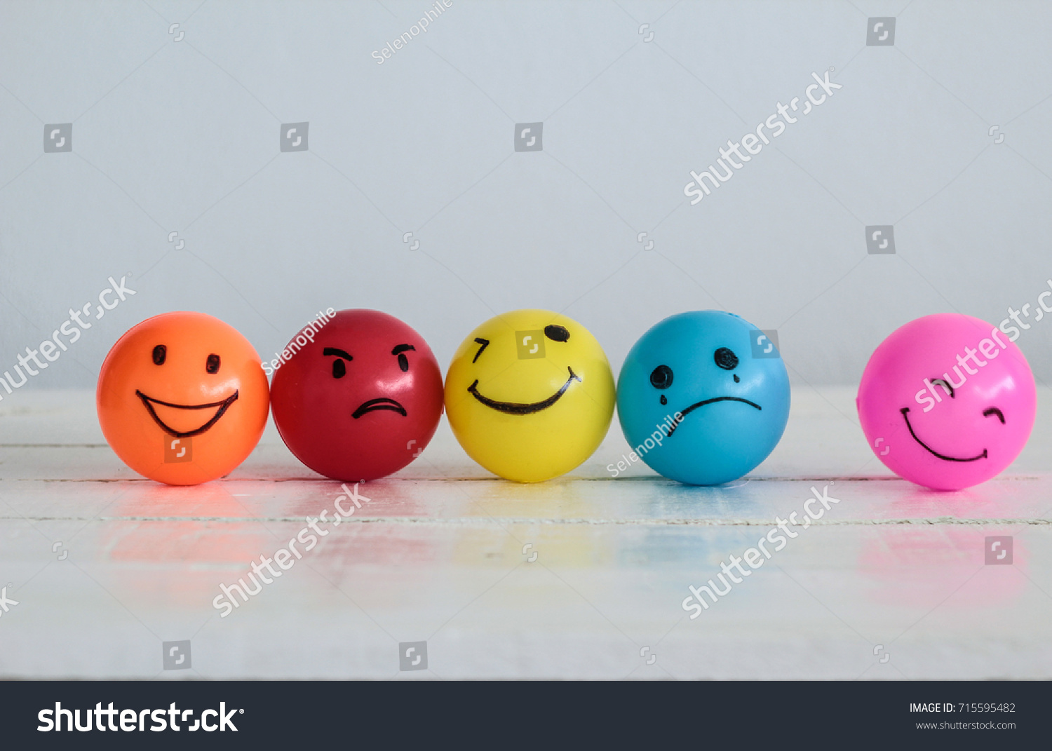 Emotions balls background, Happy Smiley faces ball in yellow , orange and pink. Sadness ball in blue and madness ball in red. Self made hand draw balls. #715595482