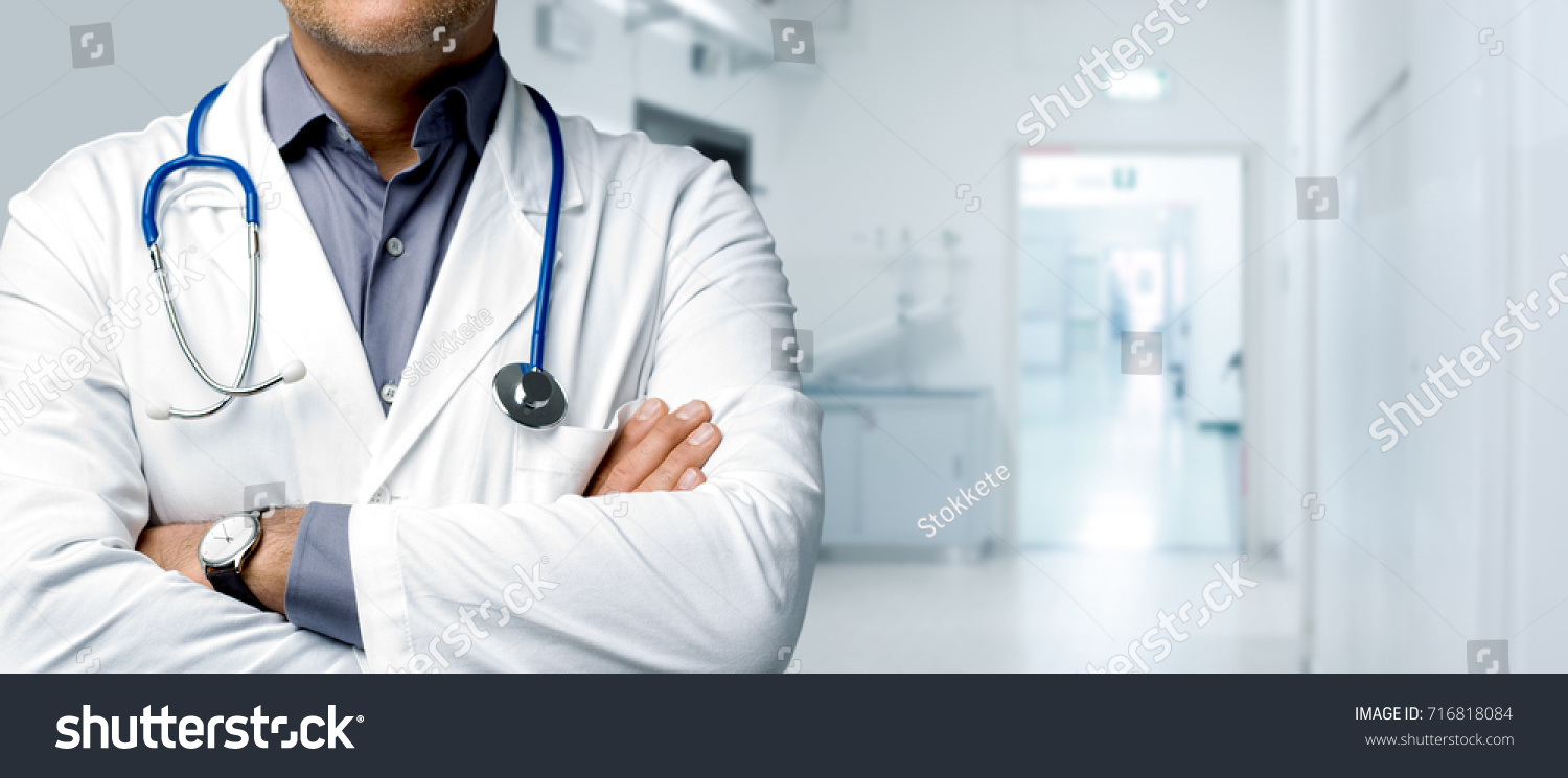 Confident doctor posing with arms crossed and stethoscope, medical advice and health insurance banner #716818084
