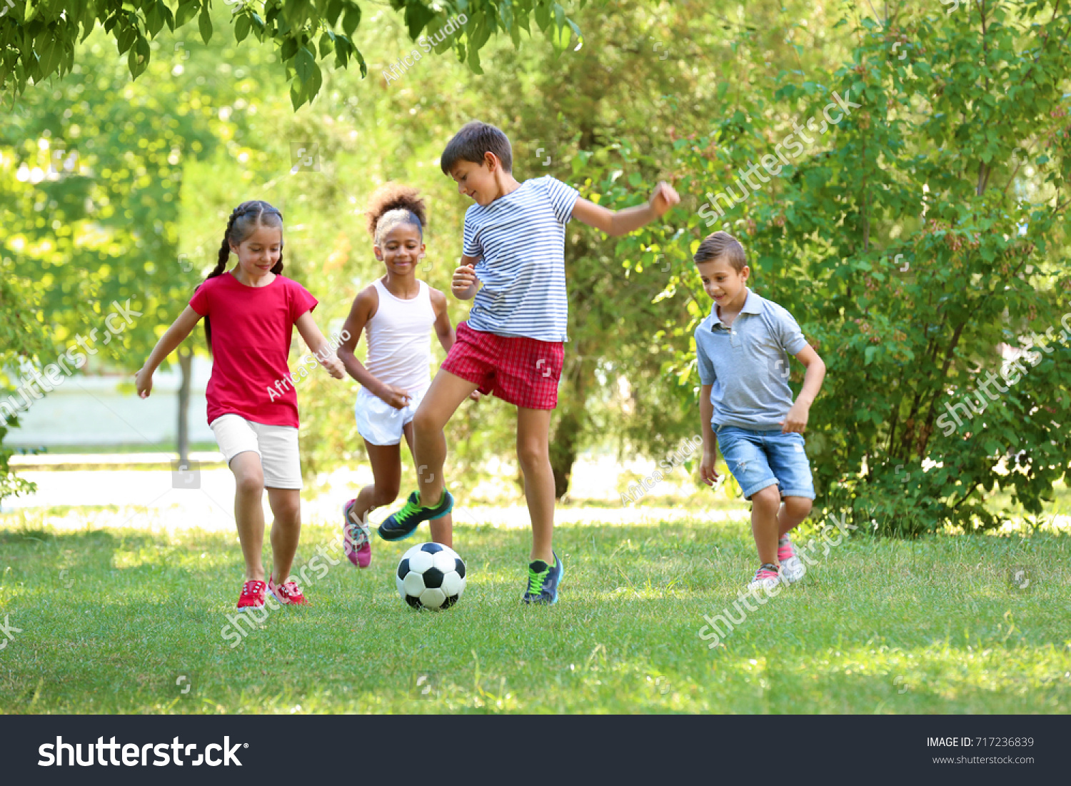 Cute children playing football in park #717236839