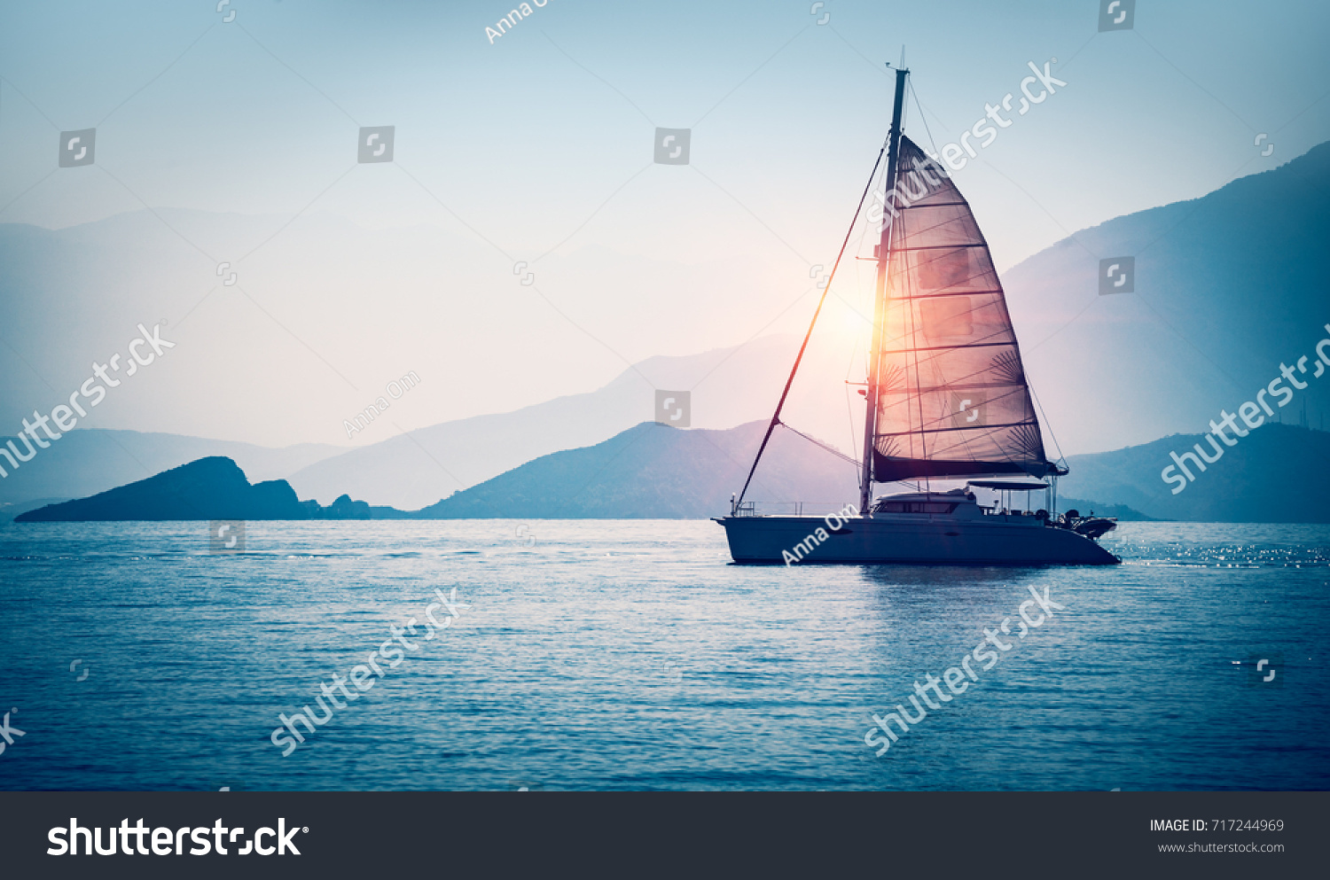 Sailboat in the sea in the evening sunlight over beautiful big mountains background, luxury summer adventure, active vacation in Mediterranean sea, Turkey #717244969