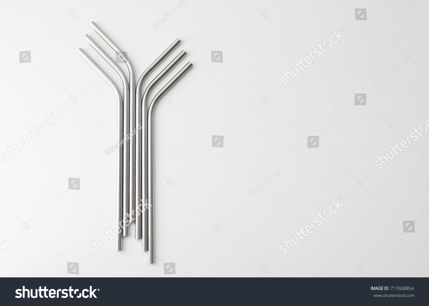 High angle view of six metal drinking straws arranged on white background #717608854