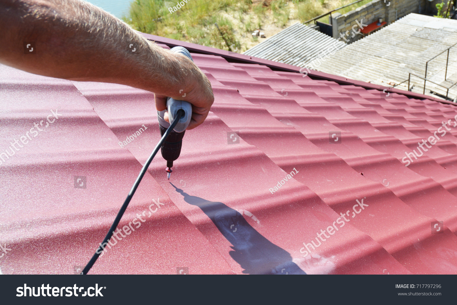 Roofing contractor installing metal roof tile for roof repair after hurricane damage. #717797296