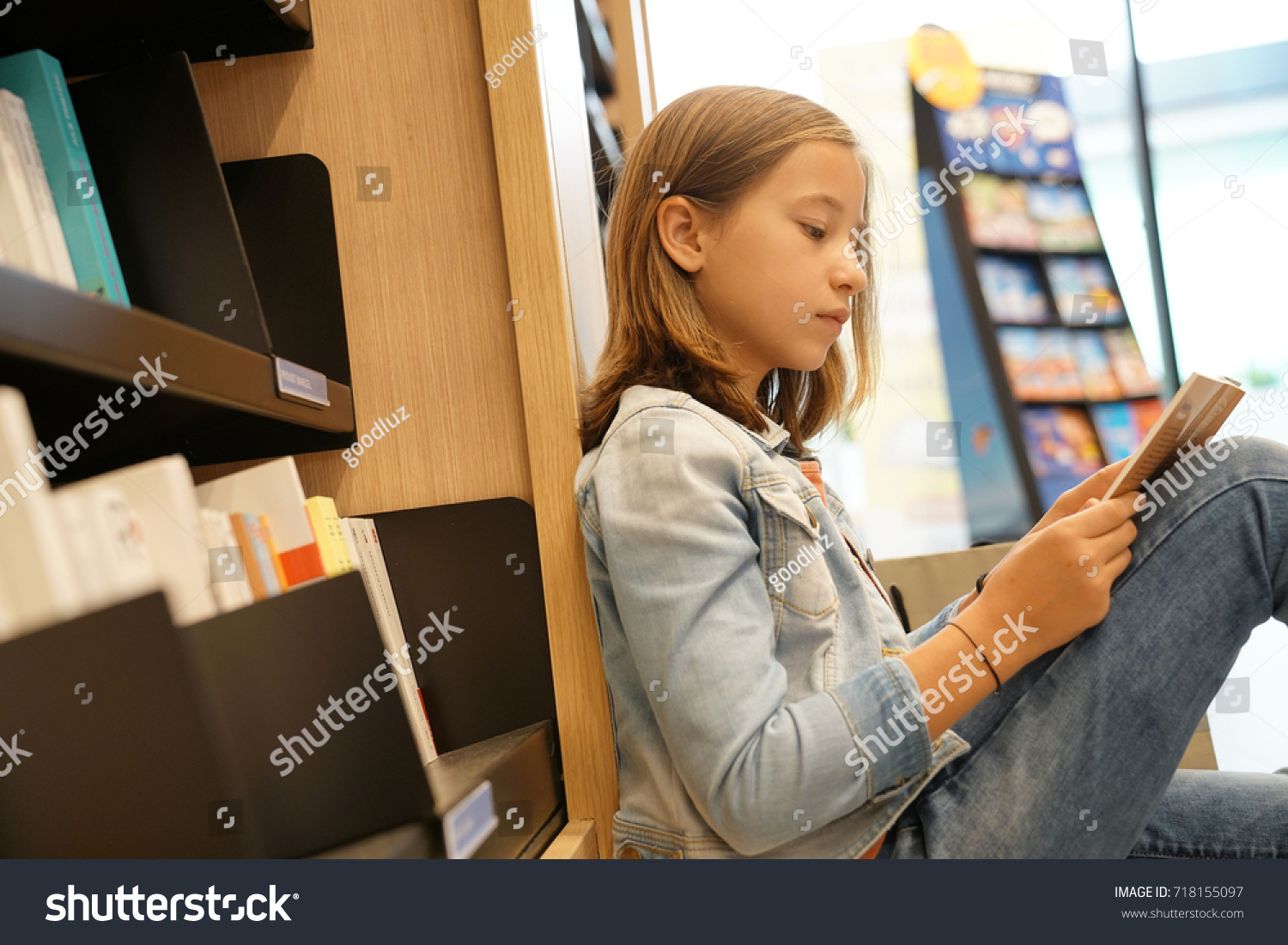 Young girl in book store reading comics #718155097