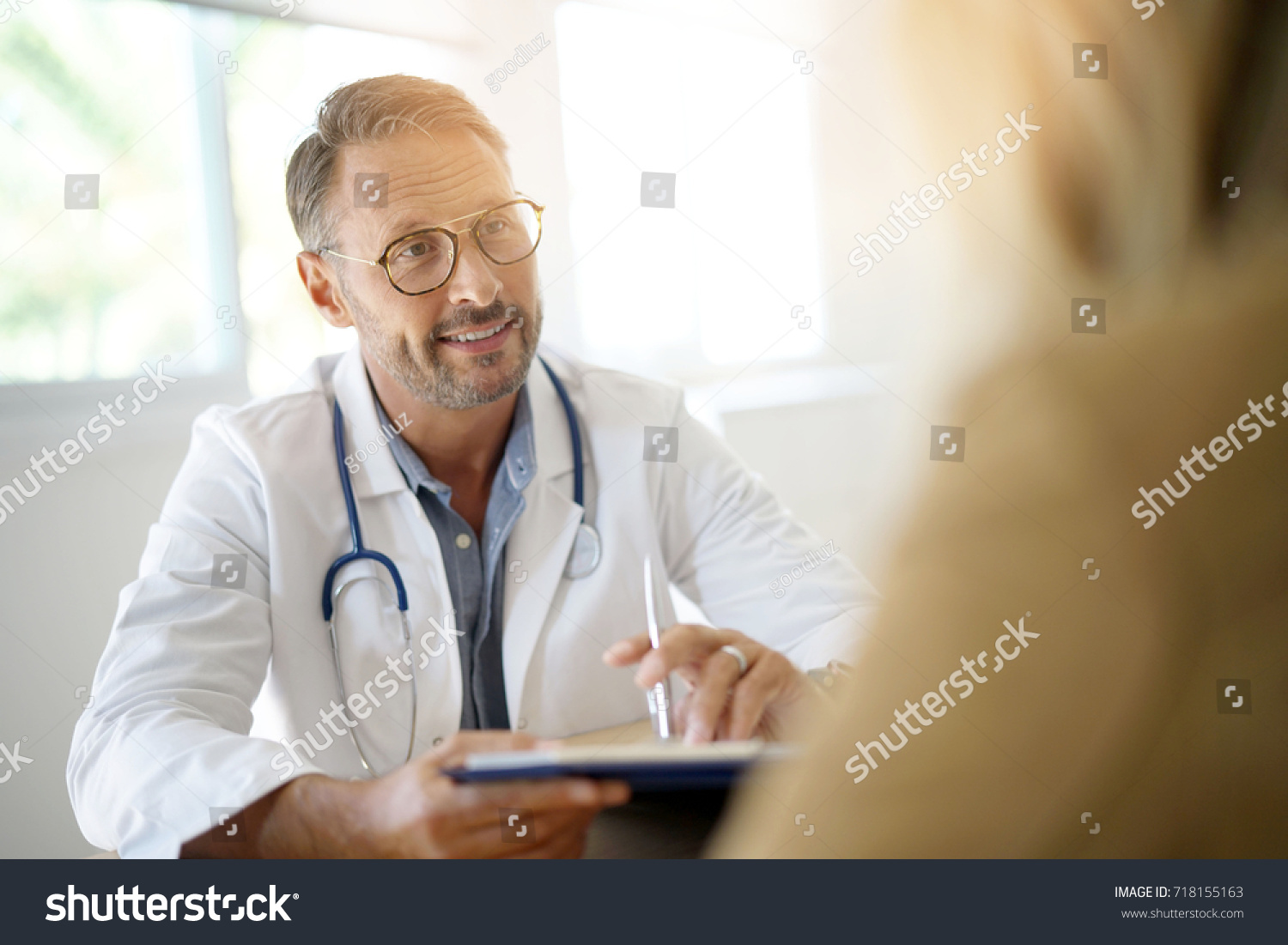Doctor with patient in medical office #718155163