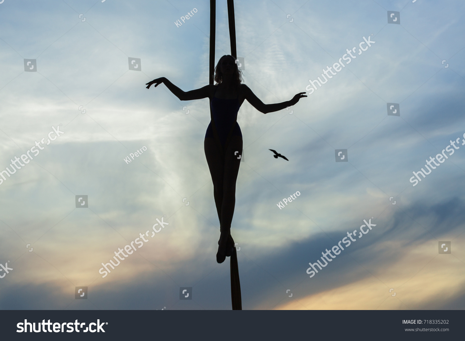 Woman balancing actor on the background of the setting sun, contours of the figure. #718335202