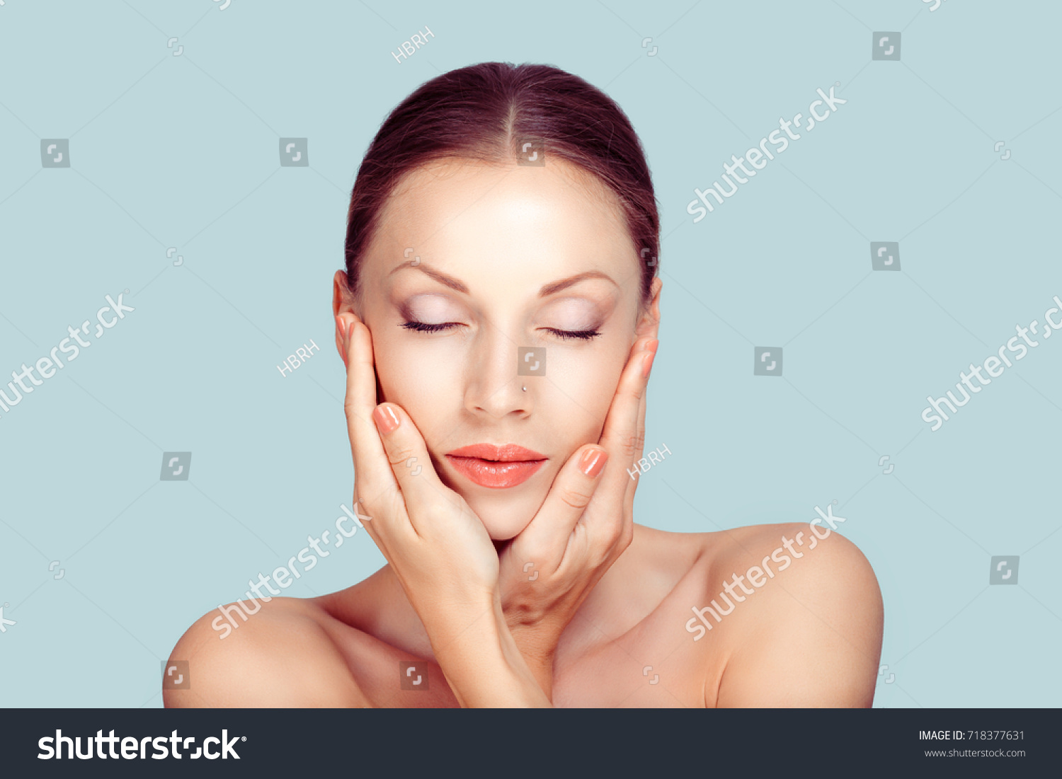 Beauty face of the young beautiful woman eyes closed - isolated on light blue #718377631