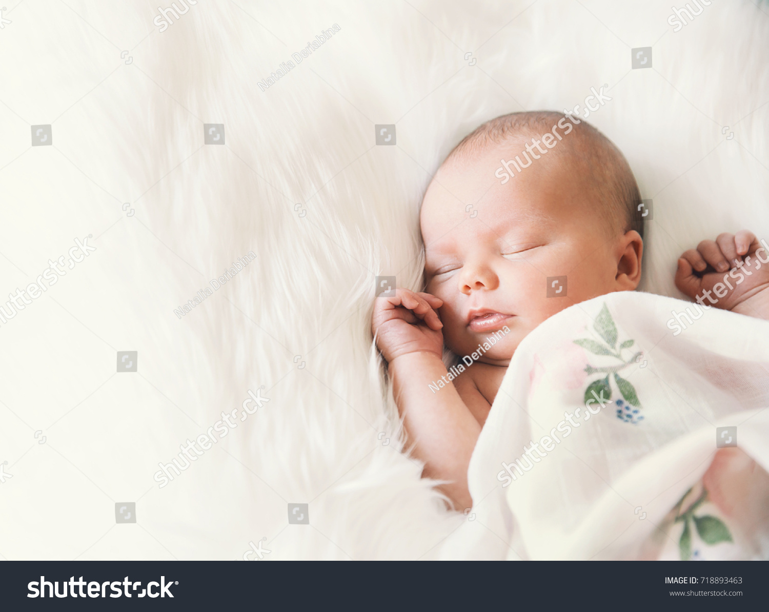 Sleeping newborn baby in a wrap on white blanket. Beautiful portrait of little child girl 7 days, one week old. #718893463