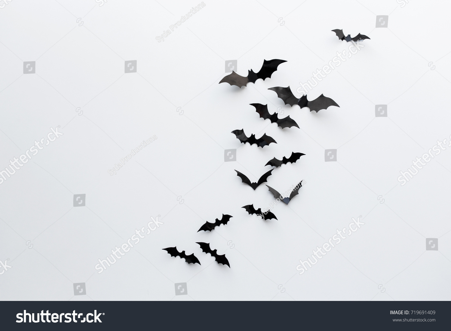 halloween and decoration concept - black paper bats flying over white background #719691409