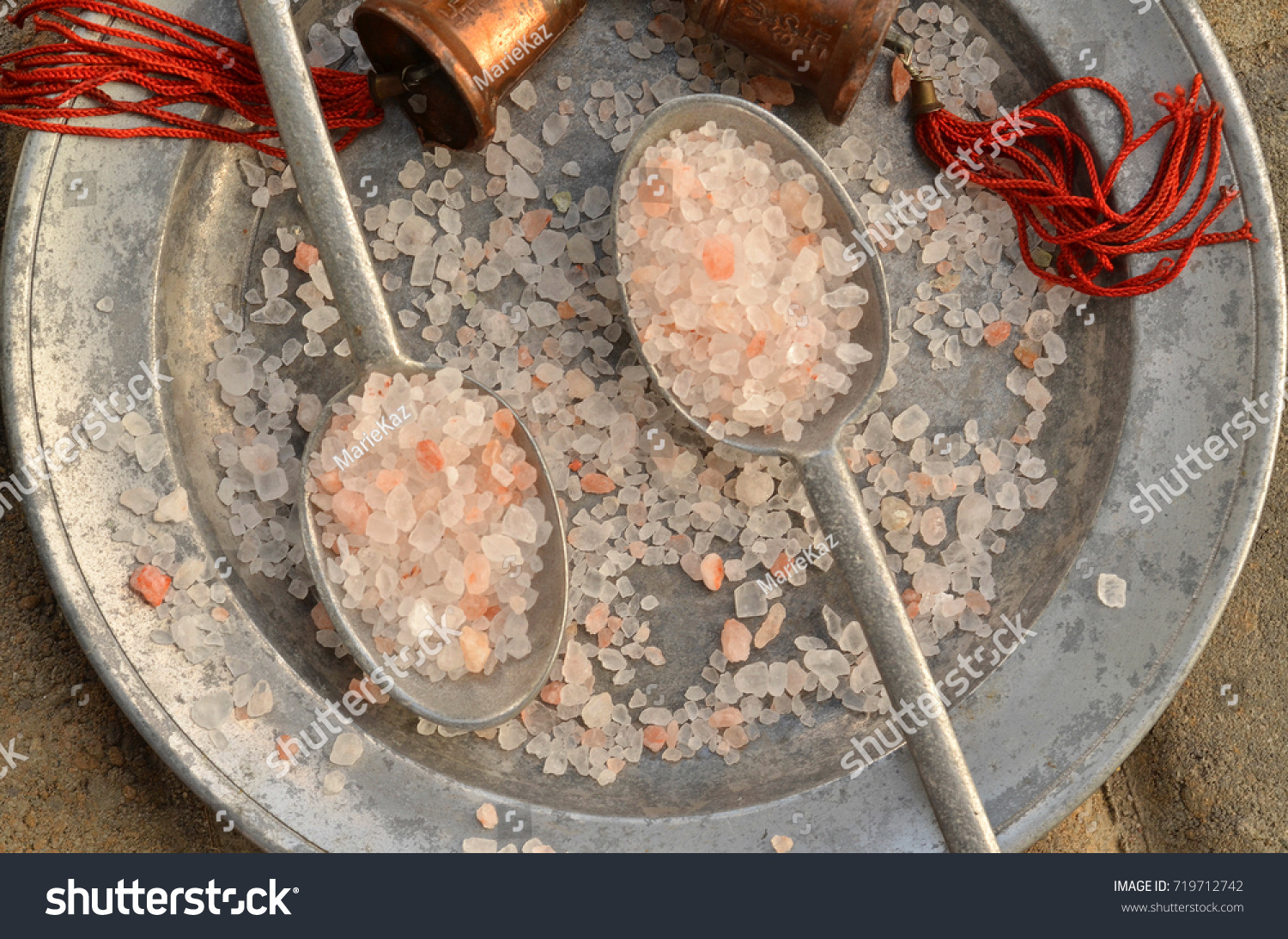 course pink Himalayan salt on pewter plate and pewter spoons and with red tasseled bells from the region #719712742