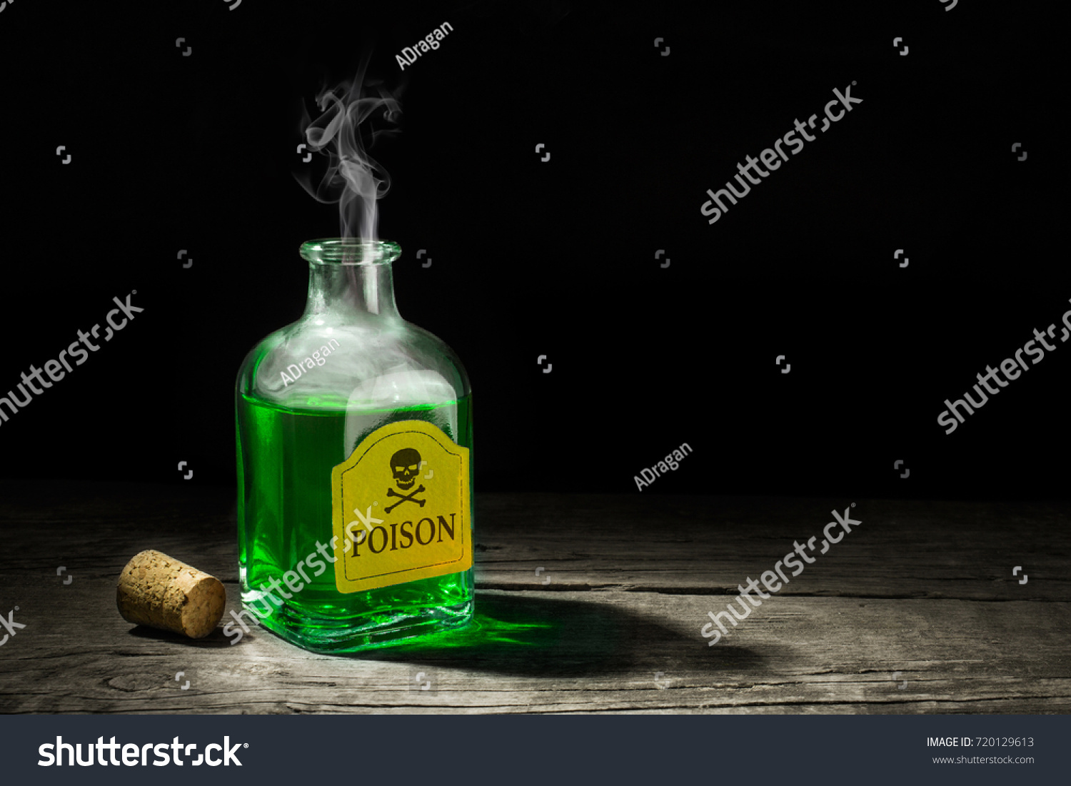 The poison is a green liquid in a glass vial. A deadly potion with a skull and bones on the label. Copy space for text. 3D rendering #720129613