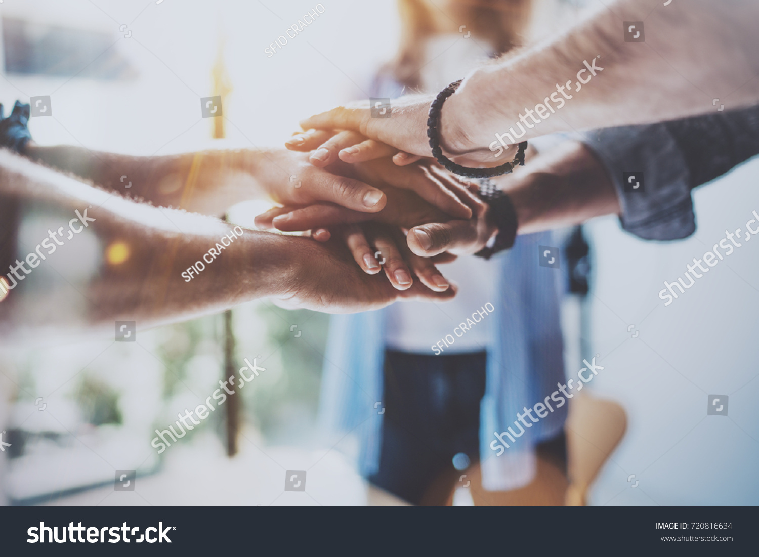 Teamwork business concept.Close up view of group of three coworkers join hand together during their meeting. Horizontal.Blurred background #720816634
