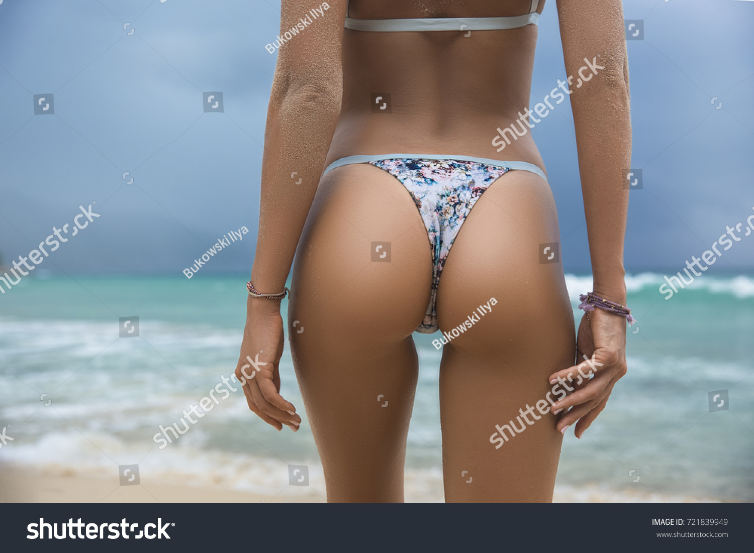 Close-up beautiful luxury slim back of a beautiful woman in a swimsuit posing in the sea water. Sexy tanned body, flat stomach, perfect figure. Rest on a tropical island. Sexy buttocks. With copyspace #721839949