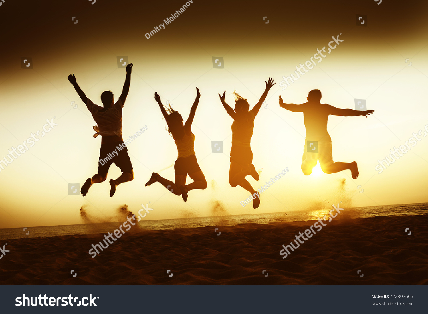 Four happy friends having fun and jumping at sunset beach #722807665