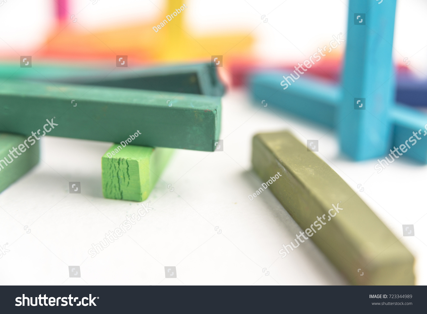 Macro of colored pastel chalks in a chaotic manner with selective focus, on white background #723344989