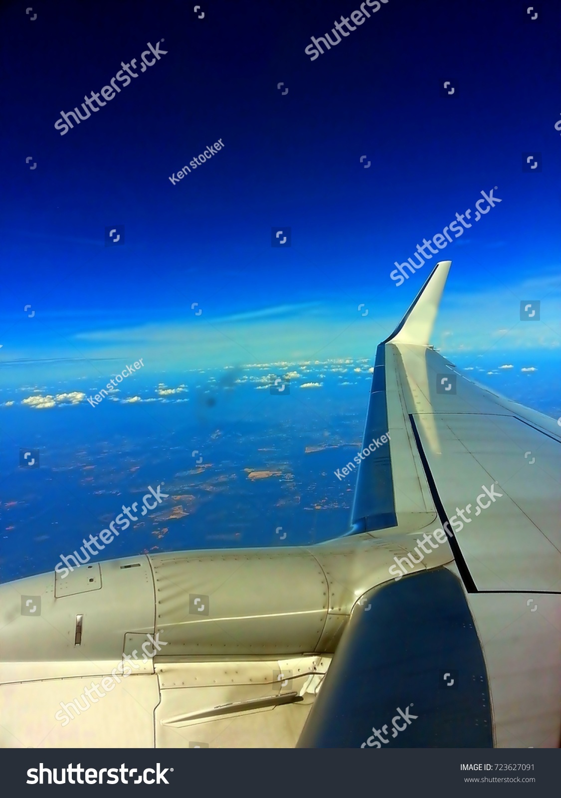 Aircraft wing with a blue sky view from the windows of airplane. #723627091