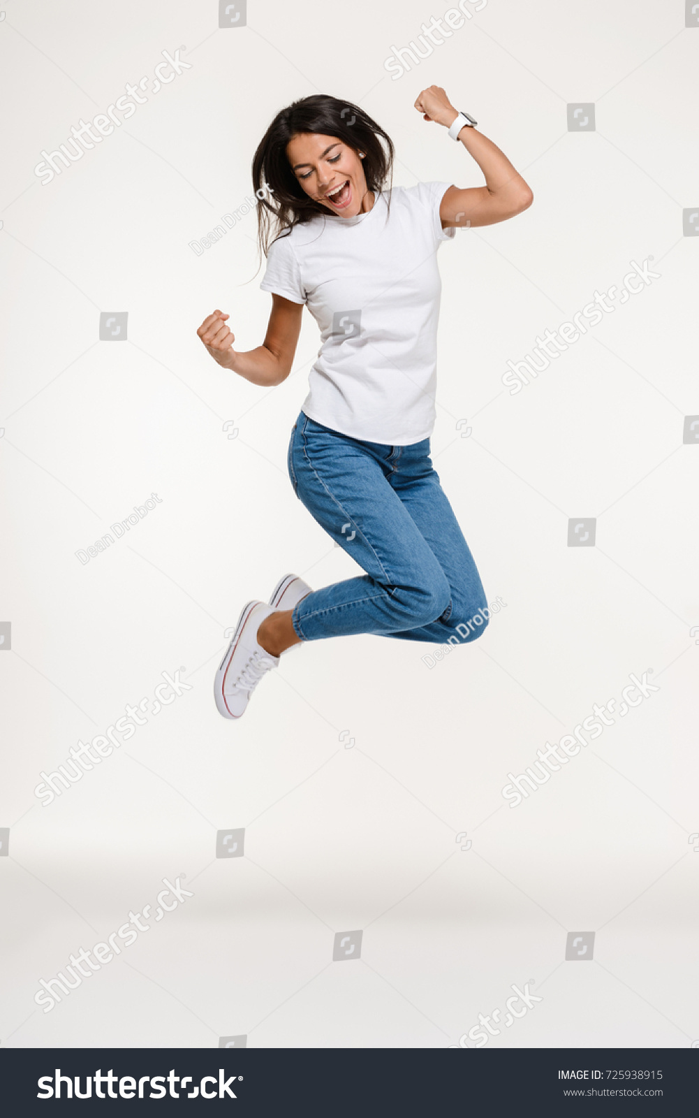 Full length portrait of a pretty joyful woman jumping isolated over white background #725938915