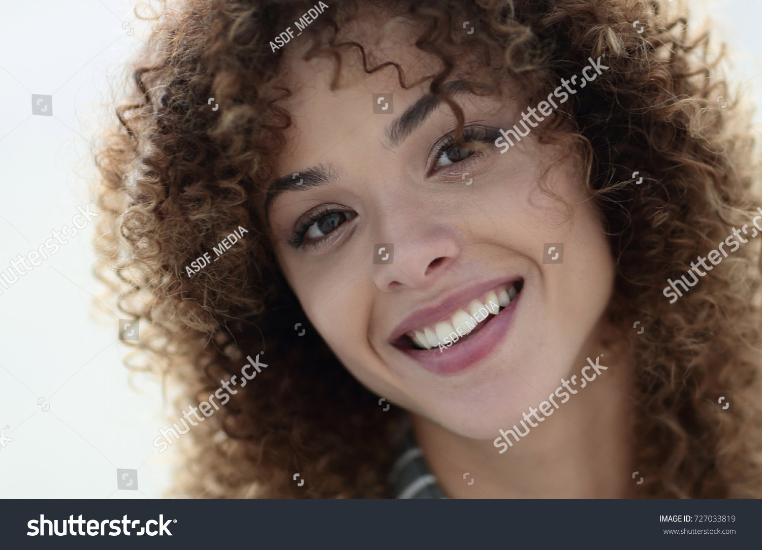 Close-up face of beautiful young woman with curly hair #727033819